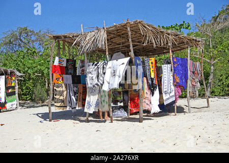Cloths, robes, mats and towels sold by hawker on stall in open market on beach, Zanzibar, Unguja Island, Tanzania. Stock Photo