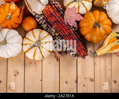 Overhead view of indian corn and mini pumpkins on a rustic wooden ...