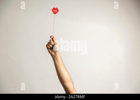 Hand holding Photo booth props, Red lips and rising it up Stock Photo