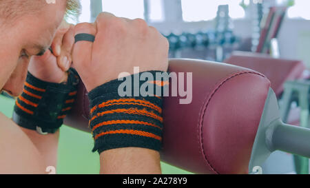 Athletic young man working out on fitness exercise equipment at gym Stock Photo