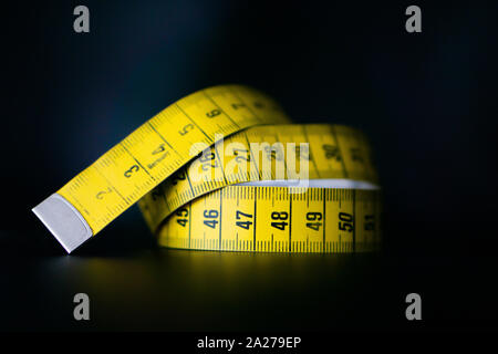 White measuring tape on a black background Stock Photo - Alamy