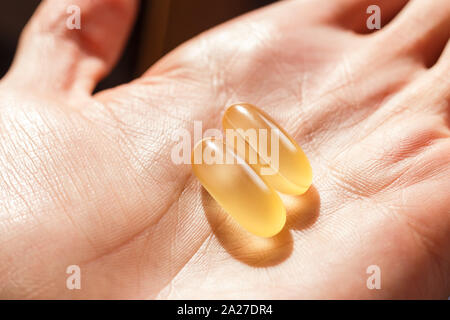 Two softgels of fish oil daily Stock Photo