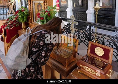 A Russian Christian pilgrim looking at some of the relics of St. Mary Magdalene kept in a special wooden box inside the Russian Orthodox Convent and church of Saint Mary Magdalene or Maria Magdalena built in 1886 by Tsar Alexander III to honor his mother, Empress Maria Alexandrovna of Russia on the slope of mount of olives East Jerusalem Israel Stock Photo