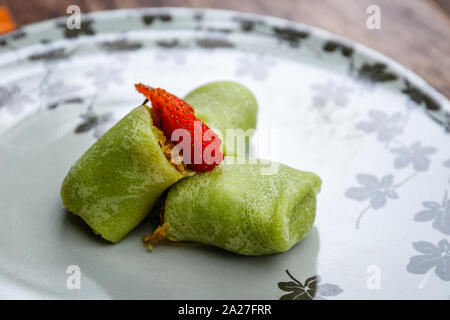 Dadar gulung, sweet coconut pancake filled with grated coconut and palm sugar. Traditional Indonesian snack Stock Photo