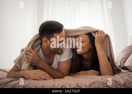 Happy couple is having fun in bed. Stock Photo