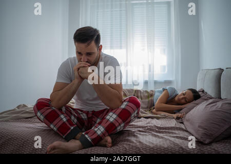 Young man is having trouble with sleep. Stock Photo