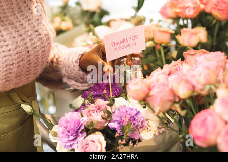 Surprise delivery. Professional florist preparing flowers, working in floral shop Stock Photo