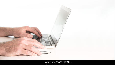 close-up of hands of person using laptop computer and wireless mouse against white background Stock Photo