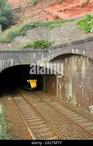 An up Great Western Intercity Express train emerging from Kennaways tunnel at Dawlish, headed by power car No 802003. 1st September 2019. Stock Photo