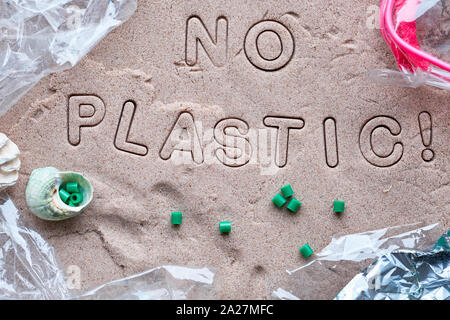 No plastic text on sand framed with various debris. Pollution is harmful to marine lives. Environmental concept. Ban single use plastic campaign. Stock Photo