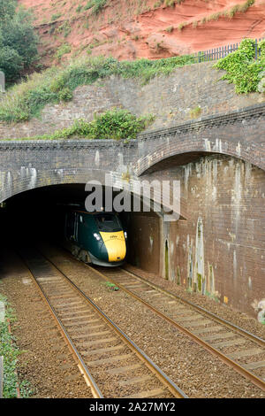 An up Great Western Intercity Express train emerging from Kennaways tunnel at Dawlish, headed by power car No 802003. 1st September 2019. Stock Photo