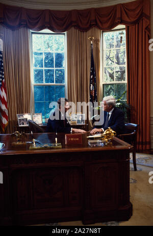 President Ronald Reagan at his desk in the White House Oval Office ...