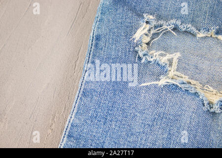 Ripped destroyed in wash blue denim jeans. isolated background Stock Photo