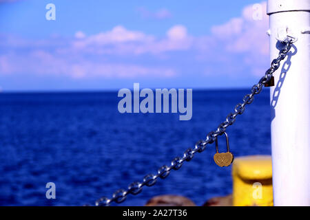 A heart-shaped padlock on the iron chain Stock Photo