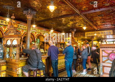 People wait to be served inside the landmark Crown Bar in downtown Belfast, Northern Ireland, United Kingdom
