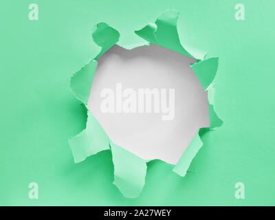 Neo mint and white torn paper, flat lay with ripped hole in the middle, copy-space Stock Photo