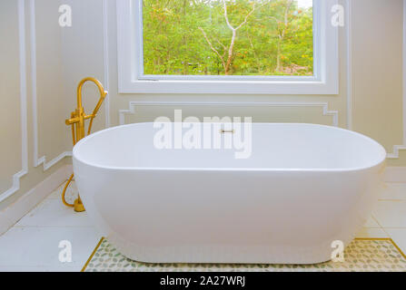 Large furnished bathroom in luxury home with bathtub white installing custom in master bathroom Stock Photo