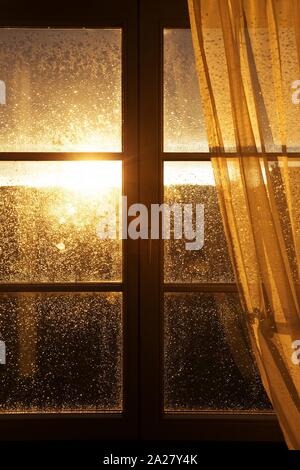 raindrops on a window pane at sunset Stock Photo