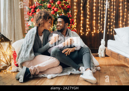 Young couple drinking coffee at Christmas tree Stock Photo