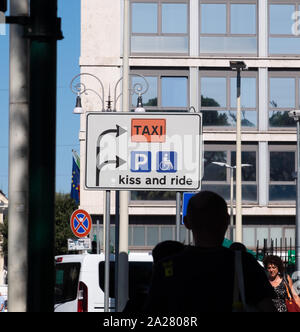 Really odd, funny directional road sign near Rome railway station highlighting taxis, parking and disabled access with the message 'Kiss and Ride' Stock Photo
