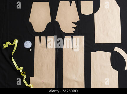The tailor lays out the pattern on the fabric in the studio. The cutter outlines the pattern in the workplace. Stock Photo
