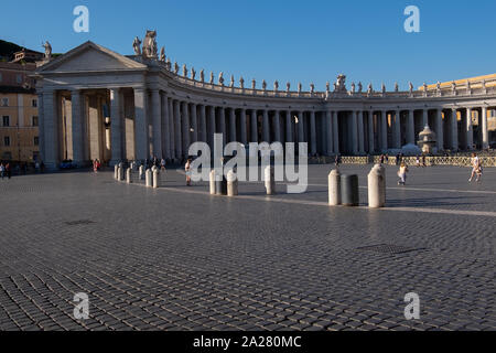 Vast impressive curved end of pillared gallery one side of St. Peter's Square, dwarfing the tiny people and unique Vatican post office below. Stock Photo