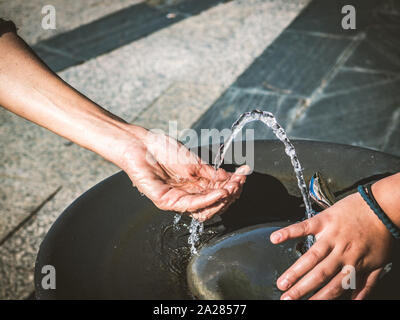 Water of a fountain pouring in woman hand Stock Photo