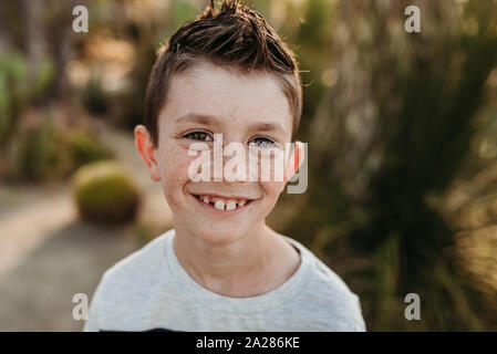 Close up portrait of cute young boy with freckles smiling Stock Photo