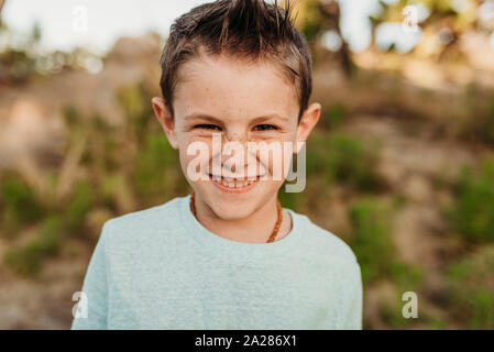 Close up portrait of cute young boy with freckles smiling Stock Photo
