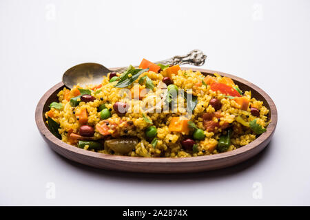 Broken wheat or Daliya Upma, served in a bowl. selective focus Stock Photo