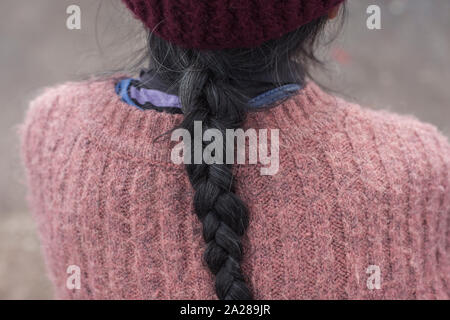 Braid of elderly woman wearing woolen outfit Stock Photo