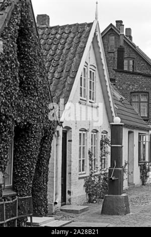 Straßenszene in einer kleinen Straße in Wyk auf der Insel Föhr, Deutschland 1960er Jahre. Street scene in a little lane at Wyk on Foehr island, Germany 1960s. Stock Photo