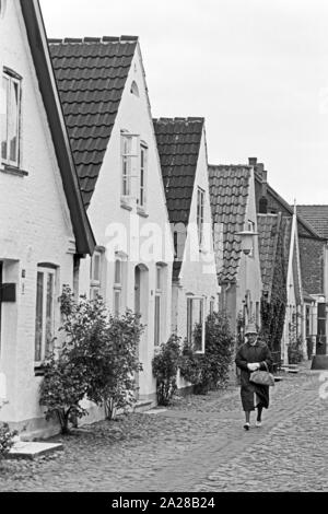 Straßenszene in einer kleinen Straße in Wyk auf der Insel Föhr, Deutschland 1960er Jahre. Street scene in a little lane at Wyk on Foehr island, Germany 1960s. Stock Photo