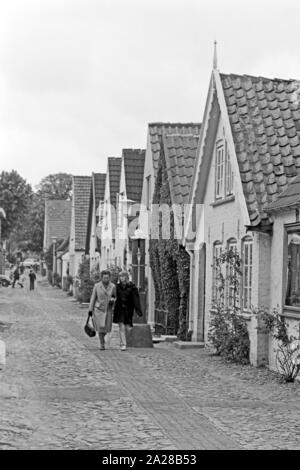 Straßenszene in einer kleinen Straße in Wyk auf der Insel Föhr, Deutschland 1960er Jahre. Street scene in a little lane at Wyk on Foehr island, Germany 1960s. Stock Photo