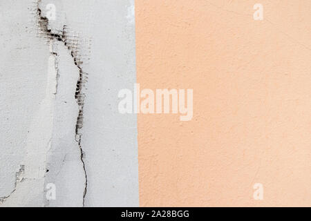 Painted in two colors plaster cracked scratched wall background Stock Photo