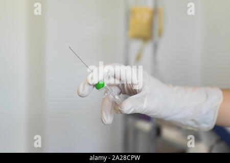 Peripheral venous catheter in the hand of a nurse in the infirmary of the hospital ward Stock Photo