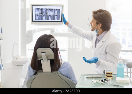 Dentist doctor showing his patient x-ray results Stock Photo