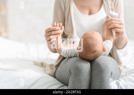 Mother holding newborn baby on lap, bonding with her child