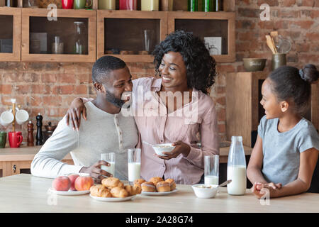 Joyful father, mother and daughter having lunch together Stock Photo