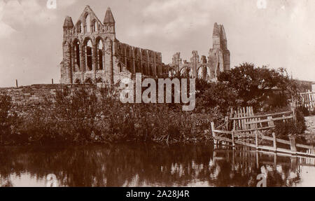 An old sepia postcard showing Whitby Abbey from the north  with the old (2nd) abbey fishpond in the foreground (now filled in). Between the pond in the picture and the abbey (and its present pond)  is the present  Hawsker road from Whitby leading to the abbey, Parish Church, Youth Hostel and the 199 steps. Stock Photo