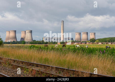 Fiddlers Ferry Power Station across a railway track and horse-filled valley from St Helen's Canal, Trans Pennine Trail, Gatewarth, Warrington Stock Photo