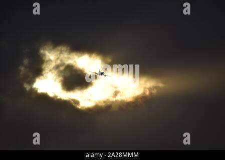 Strange sky, American refuelling plane flies towards a strange glowing hole in the black clouds. Stock Photo