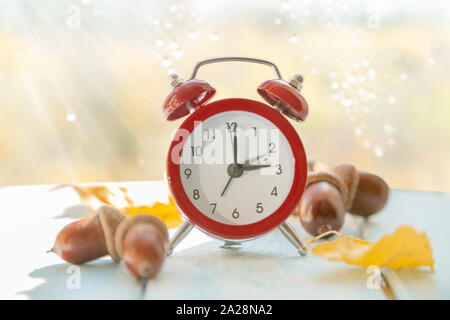 Autumn time change concept - red alarm clock on wood background Stock Photo