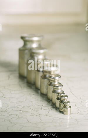 Set of pharmacy laboratory precision weights for a balance scale on an old table. Stock Photo