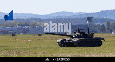 OSTRAVA, CZECH REPUBLIC - SEPTEMBER 22, 2019: NATO Days. Old Russian T-72 main battle tank and NATO flag in the battlefield. Stock Photo