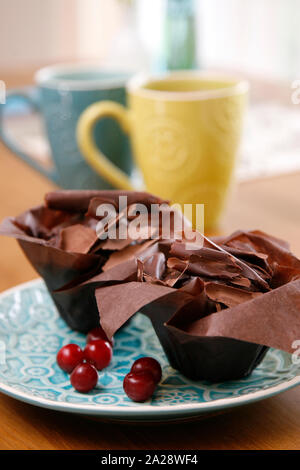 Two chocolate cupcakes covered with chocolate chips on a blue plate. Romantic breakfast for two. Stock Photo