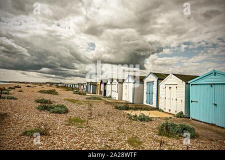 Beach huts in St. Leonard’s on sea with gathering storm clouds Stock Photo