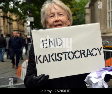 A woman holds a placard urging 'End Kakistocracy' outside the Conservative Party Conference, 2019, in Manchester, uk, on day 3. A kakistocracy is a system of government that is run by the worst, least qualified, and/or most unscrupulous citizens. Stock Photo