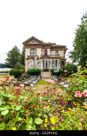 Meeker Mansion (built in 1886 in the Victorian style) and landscaping in Puyallup, Washington, with chairs out front. Stock Photo