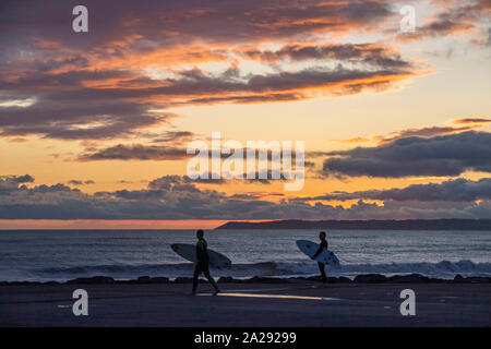 Port Talbot, UK. 01st Oct, 2019. Surfers  at Aberavon Beach in Port Tallbot watch as the sun goes down across the water at Swansea this evening duting a break in the wet and windy weather. Credit: Phil Rees/Alamy Live News Stock Photo